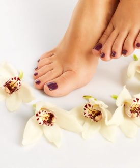 Closeup photo of a female feet with beautiful pedicure after spa procedure on white background